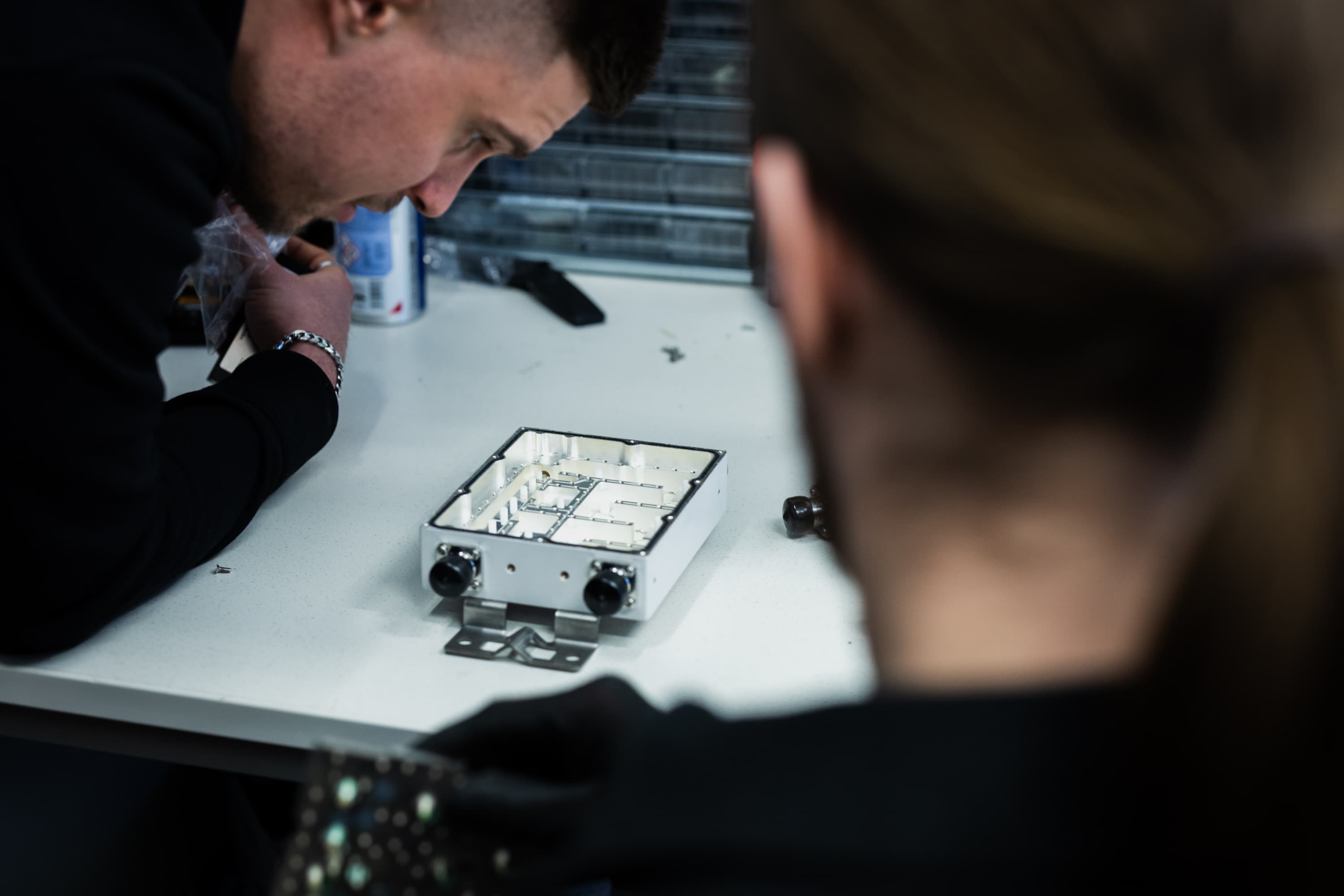 Bandercom and an installer examining the internals of an open diplexer in the workshop